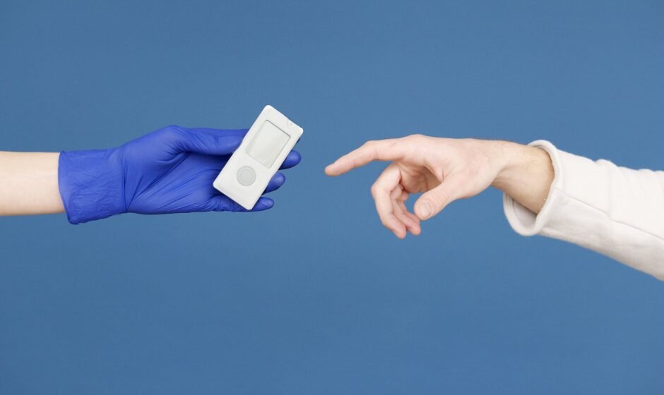 person s hand in latex gloves holding a glucometer