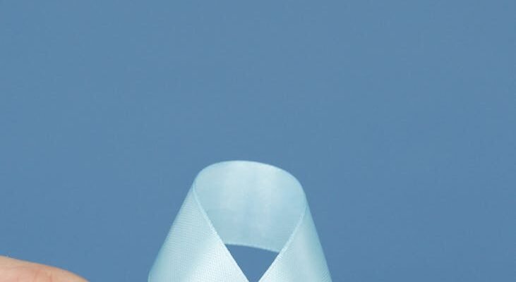 person holding a white diabetes awareness ribbon with decorated blood drop