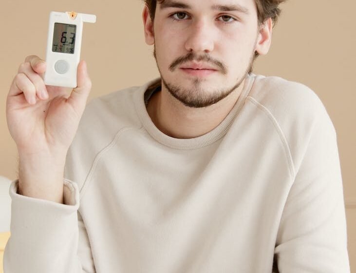 young man holding a glucometer