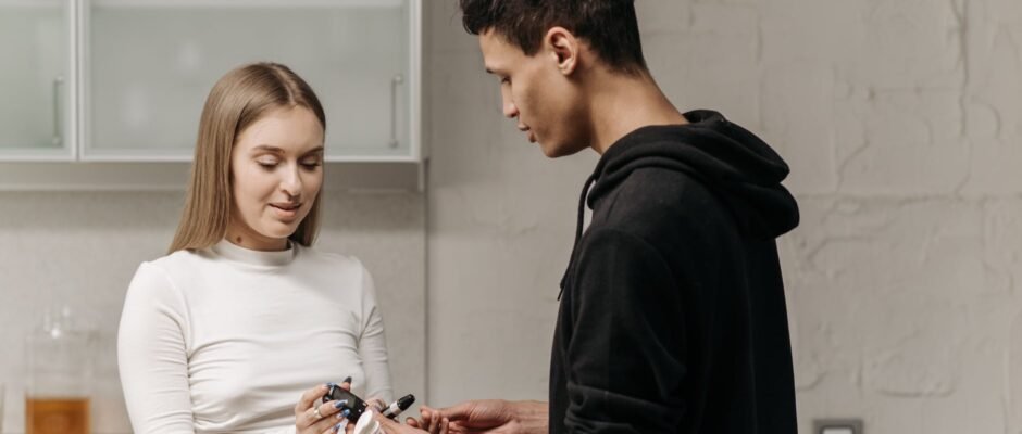 a woman handing the glucose meter to the man wearing black hoodie