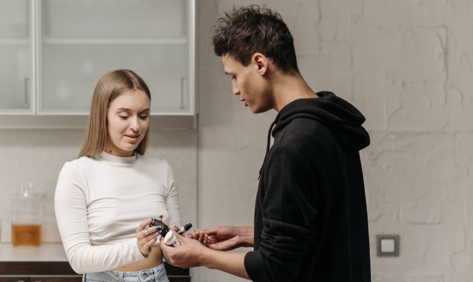 a woman handing the glucose meter to the man wearing black hoodie